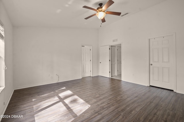 empty room with dark hardwood / wood-style flooring, high vaulted ceiling, and ceiling fan