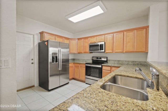 kitchen with light stone countertops, sink, light brown cabinets, stainless steel appliances, and light tile patterned floors