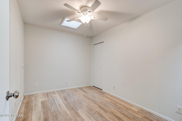 5 Park Pl, Ormond Beach, FL 32174 - spare room with a ceiling fan, light wood-style flooring, a skylight, and a textured ceiling