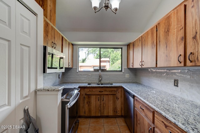5 Park Pl, Ormond Beach, FL 32174 - kitchen with appliances with stainless steel finishes, brown cabinets, light tile patterned floors, and a chandelier