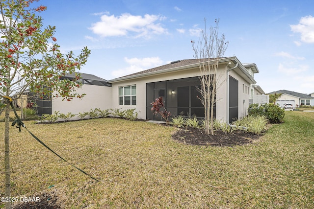 rear view of property with a yard and a sunroom