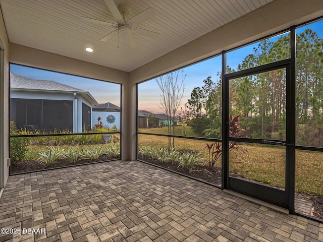 unfurnished sunroom featuring ceiling fan