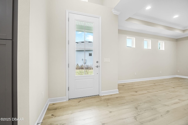 entryway with light wood-type flooring, a healthy amount of sunlight, and crown molding