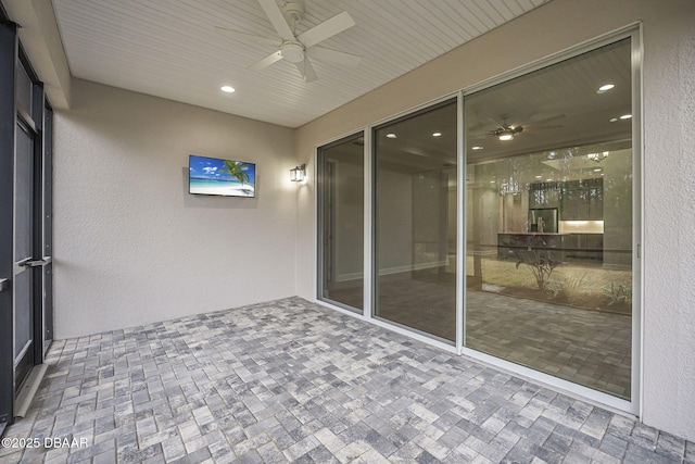 unfurnished sunroom with ceiling fan