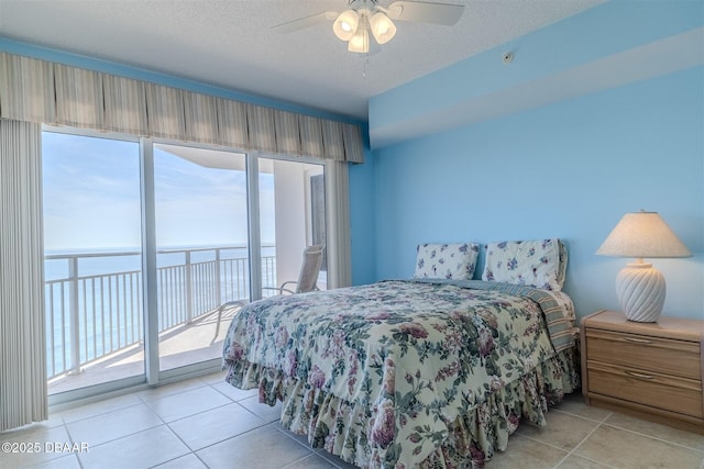 bedroom featuring a textured ceiling, access to outside, light tile patterned floors, and ceiling fan