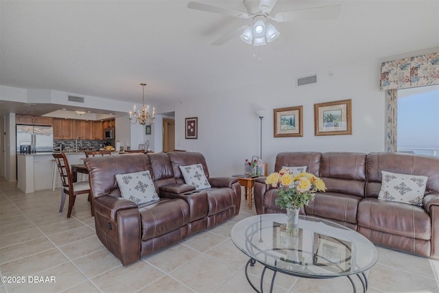 living room featuring light tile patterned floors, visible vents, and ceiling fan with notable chandelier