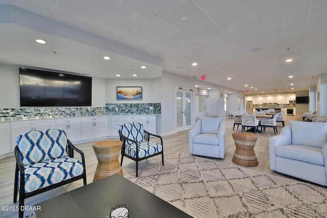 living area with baseboards, light wood-style floors, and recessed lighting