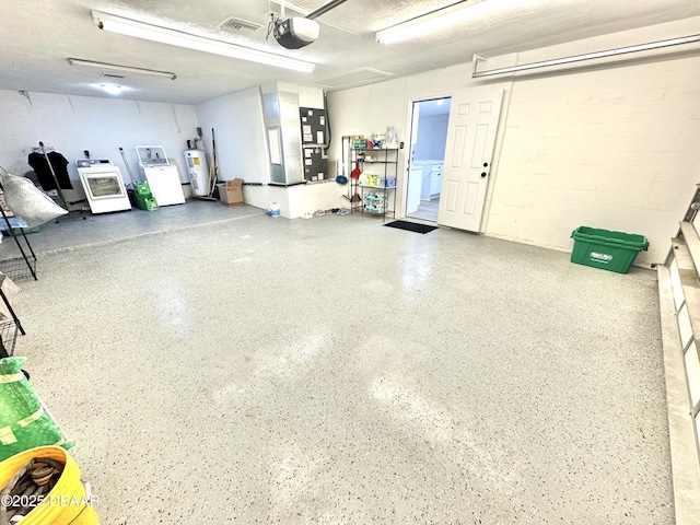 garage with washing machine and dryer, water heater, and a garage door opener