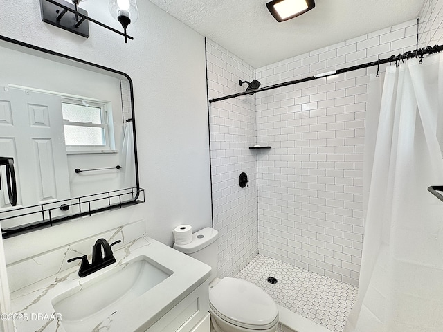 bathroom featuring a textured ceiling, vanity, toilet, and walk in shower