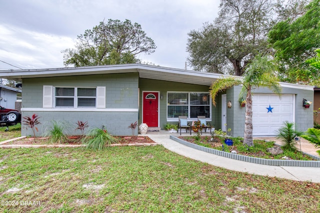 single story home with a front lawn, a porch, and a garage