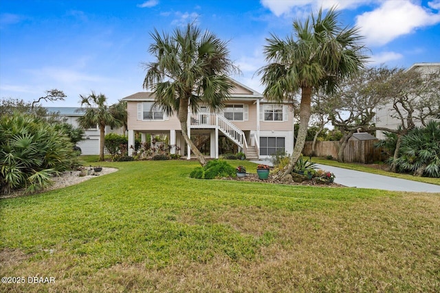 view of front of house featuring a front yard, covered porch, and a garage