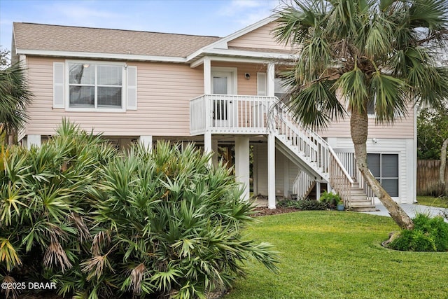 raised beach house featuring a front lawn