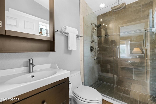 bathroom with toilet, vanity, and walk in shower