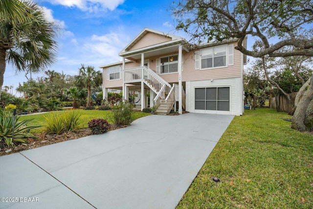 raised beach house with a front lawn, covered porch, and a garage