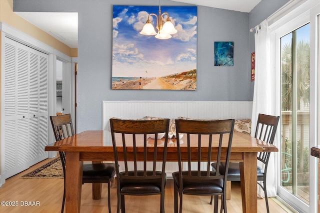 dining space featuring light hardwood / wood-style flooring and a notable chandelier