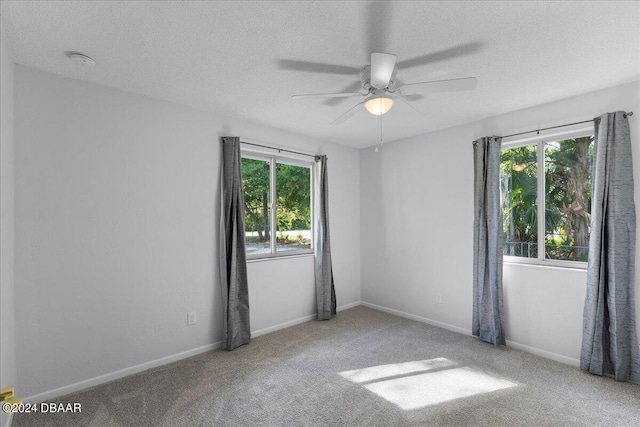 carpeted empty room featuring ceiling fan and a textured ceiling