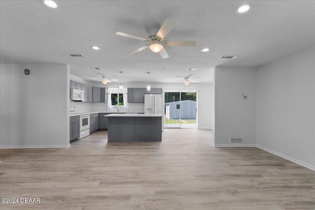 kitchen with light hardwood / wood-style floors, white appliances, a kitchen island, gray cabinets, and pendant lighting