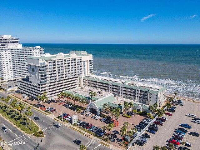 drone / aerial view featuring a water view and a view of the beach