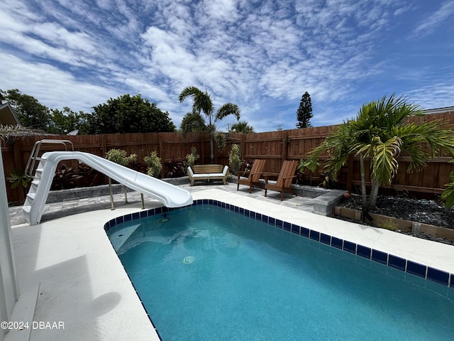 view of swimming pool featuring a patio and a water slide