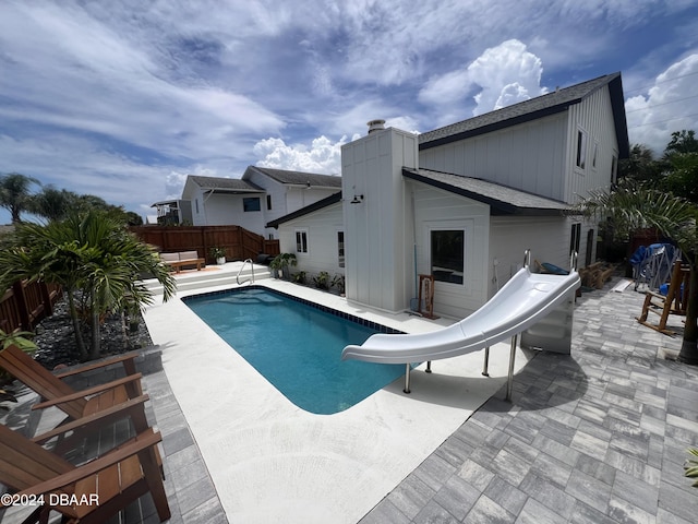 view of swimming pool with a patio and a water slide