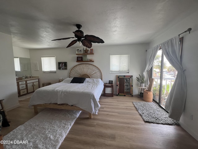 bedroom with access to outside, ceiling fan, light hardwood / wood-style flooring, and sink