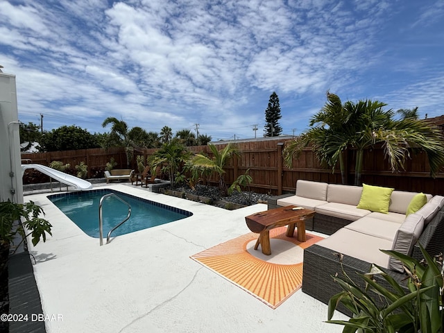 view of swimming pool with outdoor lounge area, a patio area, and a water slide