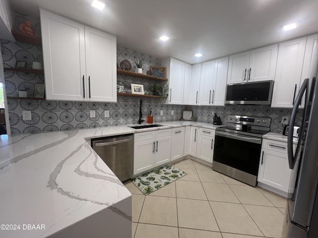 kitchen with white cabinets, light stone countertops, sink, and appliances with stainless steel finishes