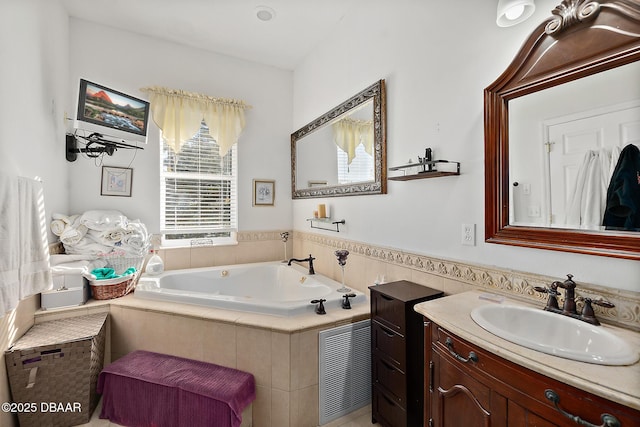 bathroom with vanity and tiled tub