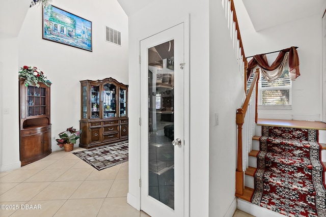 corridor featuring light tile patterned flooring and lofted ceiling