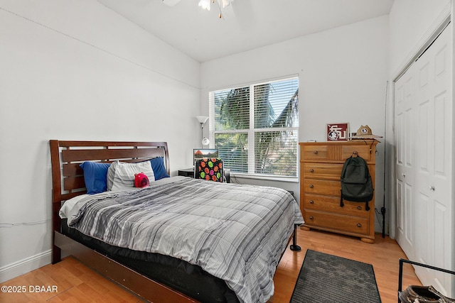 bedroom with ceiling fan, a closet, and light hardwood / wood-style flooring