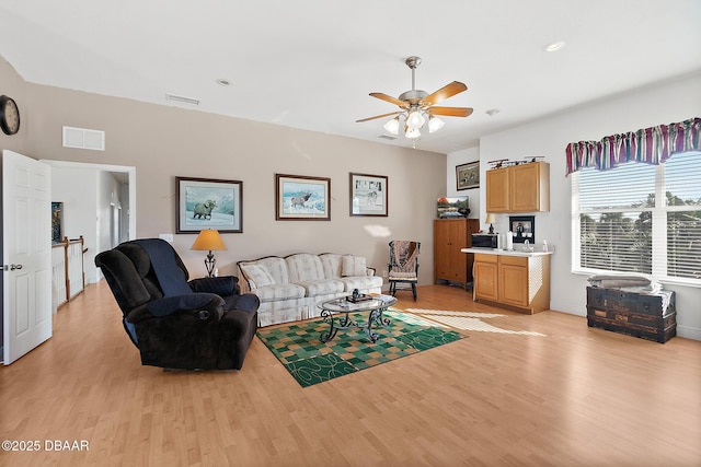 living room featuring light hardwood / wood-style flooring and ceiling fan