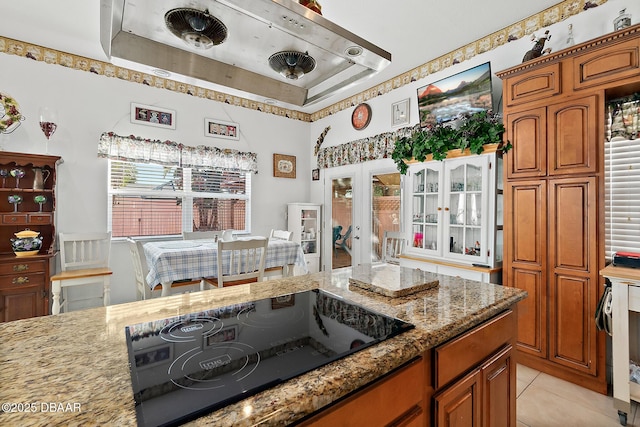 kitchen featuring black electric cooktop, light tile patterned flooring, light stone counters, and french doors