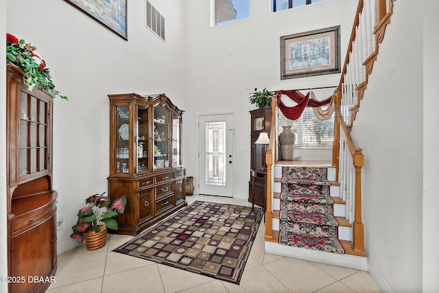 tiled foyer entrance with a towering ceiling