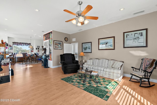 living room with ceiling fan and wood-type flooring