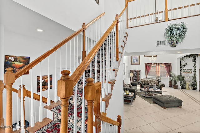 stairs with an inviting chandelier and tile patterned floors