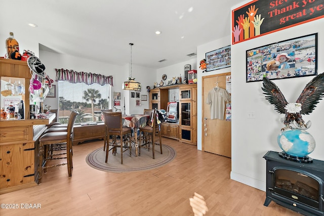 dining area featuring a wood stove and light hardwood / wood-style floors