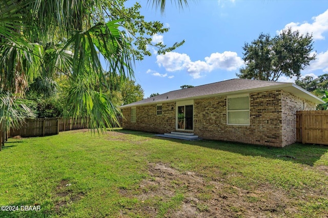 rear view of house featuring a lawn