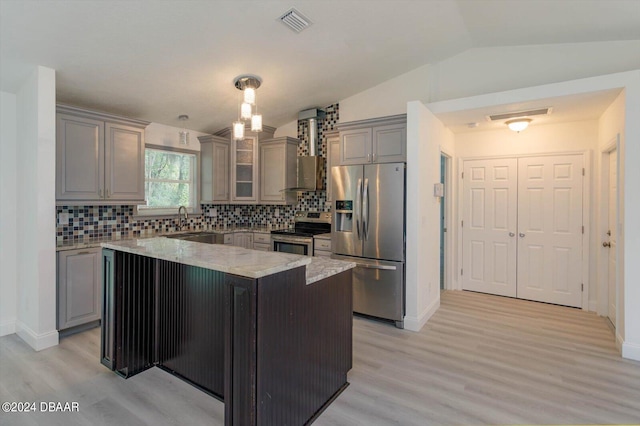 kitchen featuring appliances with stainless steel finishes, tasteful backsplash, light hardwood / wood-style flooring, a kitchen island, and pendant lighting