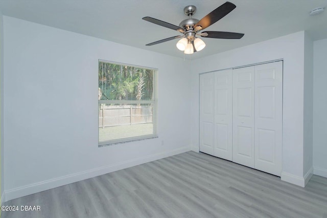 unfurnished bedroom featuring light wood-type flooring, ceiling fan, and a closet