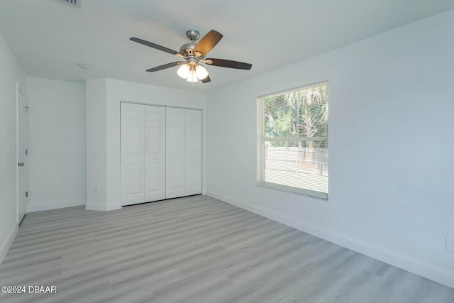 unfurnished bedroom featuring light hardwood / wood-style floors, ceiling fan, and a closet