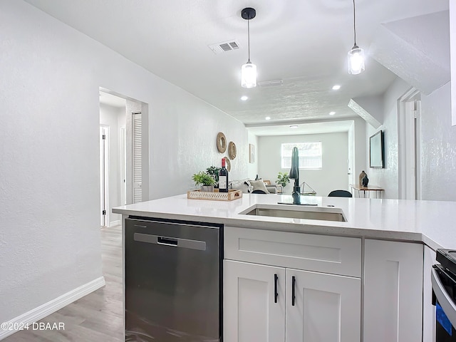 kitchen with appliances with stainless steel finishes, light hardwood / wood-style flooring, pendant lighting, and sink