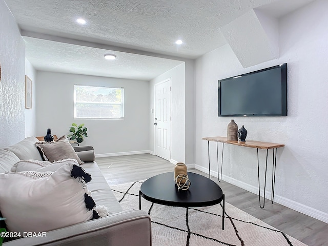 living room featuring a textured ceiling and light hardwood / wood-style floors