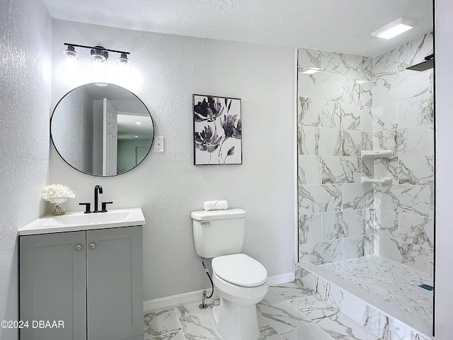 bathroom with vanity, toilet, a textured ceiling, and a tile shower