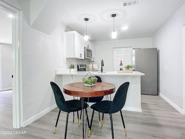 dining room with light wood-type flooring and sink