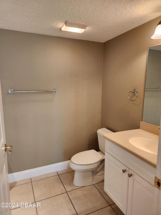 bathroom featuring vanity, tile patterned floors, toilet, and a textured ceiling