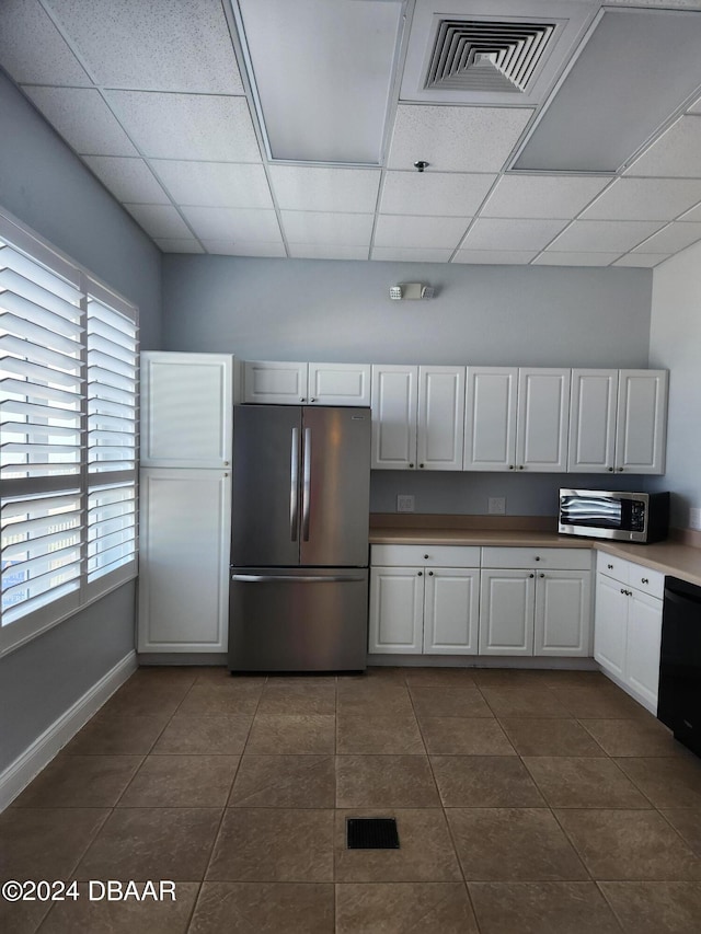4670 Links Village Dr Unit D204, Ponce Inlet, FL 32127 - kitchen with appliances with stainless steel finishes, white cabinetry, a drop ceiling, dark tile patterned floors, and baseboards