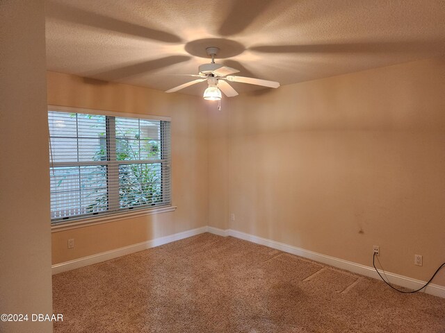 unfurnished room with ceiling fan, a textured ceiling, and carpet floors