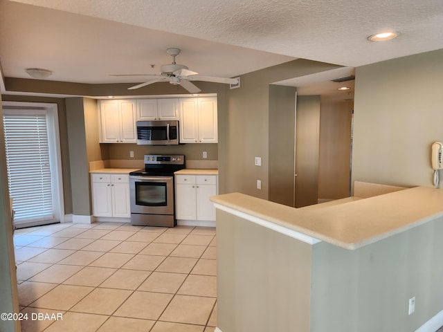 4670 Links Village Dr Unit D204, Ponce Inlet, FL 32127 - kitchen featuring stainless steel appliances, white cabinets, light tile patterned floors, a ceiling fan, and a textured ceiling