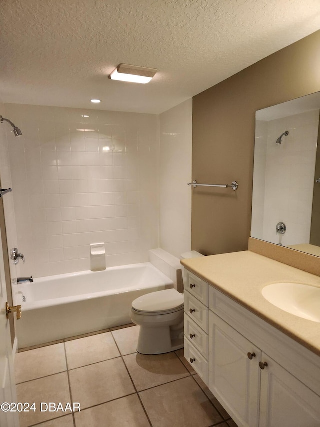 full bathroom featuring vanity, a textured ceiling, tile patterned flooring, toilet, and tiled shower / bath