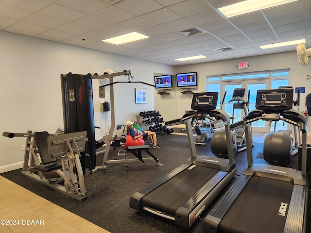 gym featuring tile patterned flooring and a drop ceiling